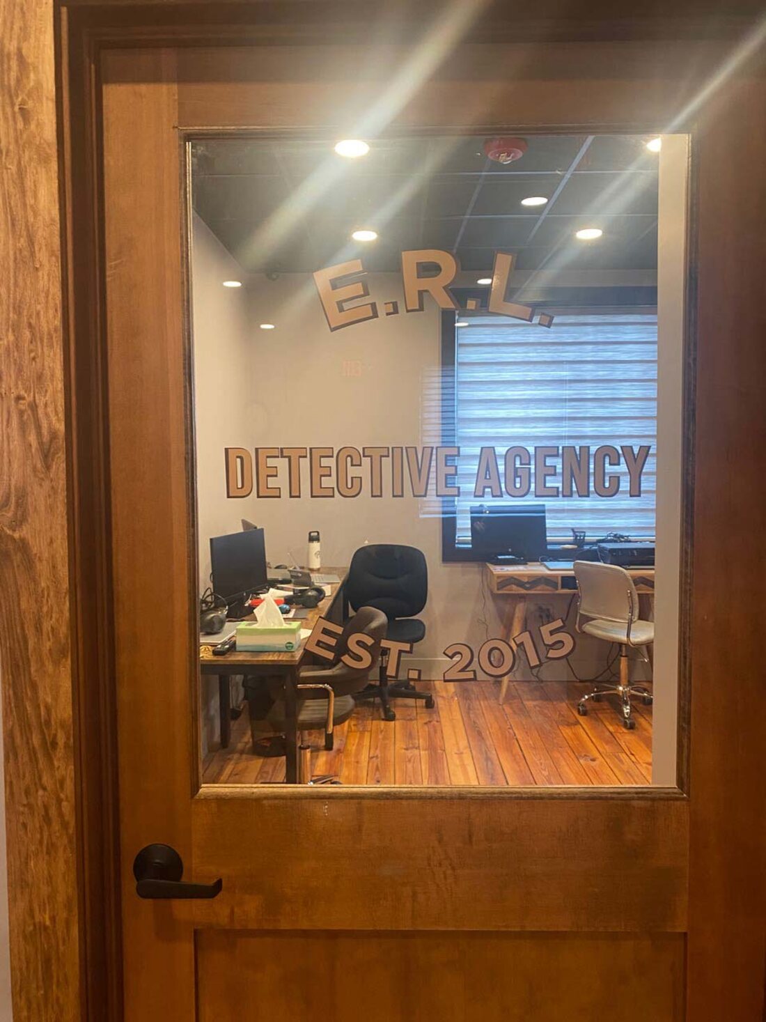 A frosted-look window film with cut lettering on a glass office door for the E.R.L. Detective Agency, installed by Weber