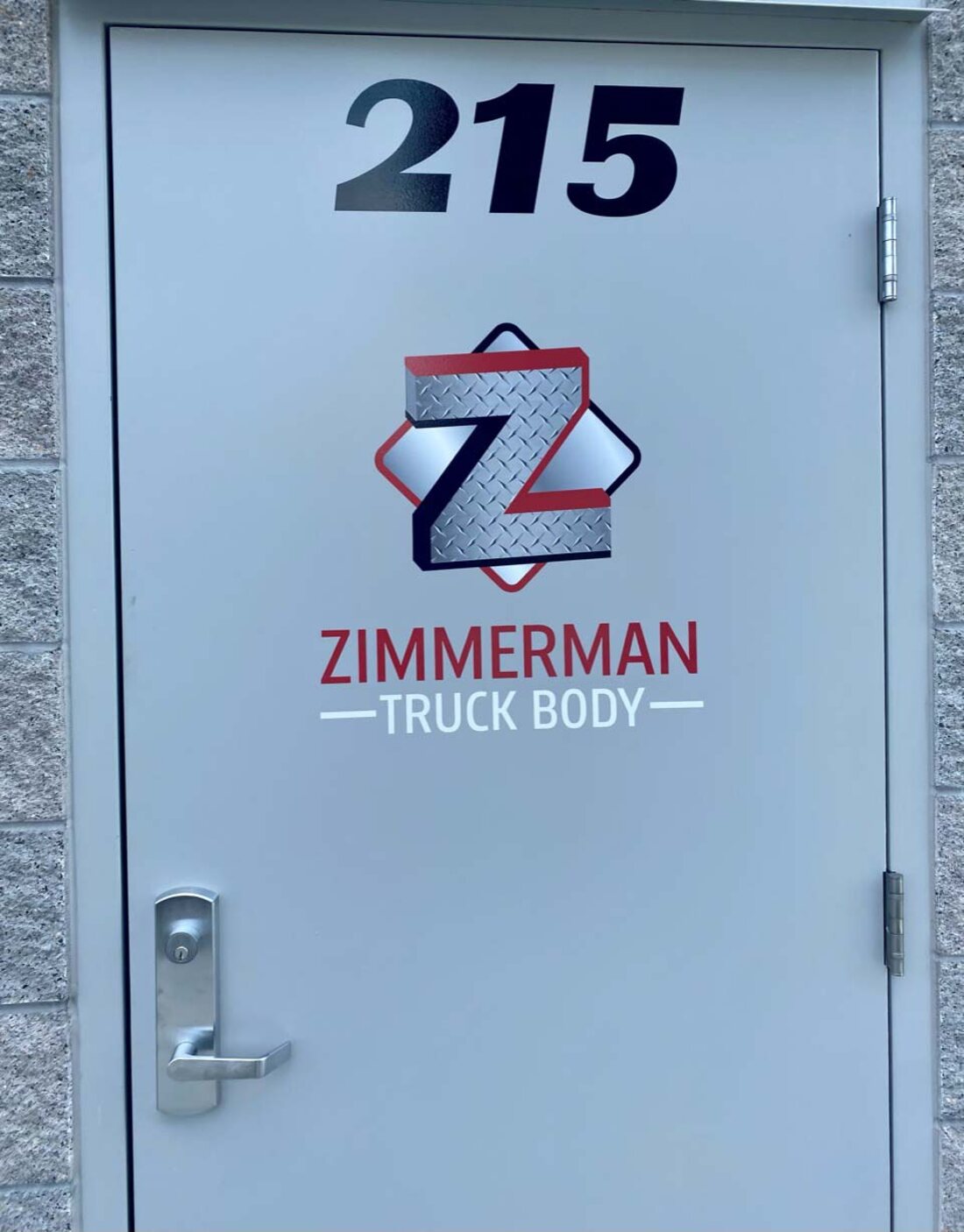 Cut-vinyl logo, suite number, and lettering applied to a metal entry door for Zimmerman Truck Body by Weber